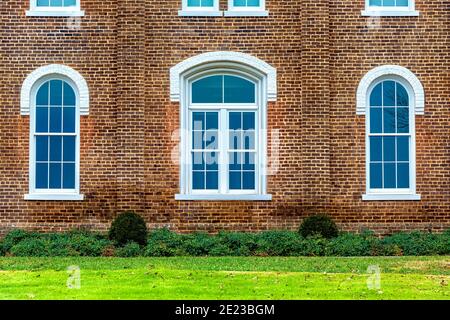 Plan horizontal de fenêtres voûtées sur le côté d'un vieux bâtiment en briques. Banque D'Images