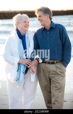 Portrait d'un couple marié plus âgé tenant les mains et en riant Plage Banque D'Images