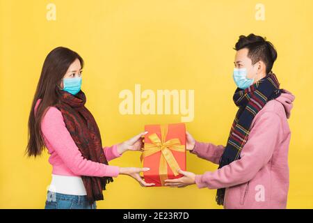 joyeux jeune couple asiatique sous masque facial et célébrant le nouvel an chinois. Banque D'Images