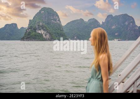 Belle femme dans une robe voyage en bateau à Halong Bay. Vietnam. Voyage en Asie, bonheur émotion, concept de vacances d'été. Mer pittoresque Banque D'Images