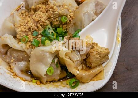 Gros plan de la cuisine taïwanaise traditionnelle taïwanaise épicée à la vapeur sur une vieille table en bois au restaurant Food Night Market à Taipei, Taïwan. Banque D'Images