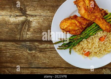 Pilons de poulet rôtis avec riz sur fond rustique en bois. Vue de dessus. Banque D'Images