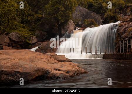 Écoulement fluide et soyeux de l'eau dans les chutes Thirumoorthy (aussi connu sous le nom de chutes Panchalingam en langue tamoule), Udumalpet, Tamil Nadu, Inde. Foc sélectif Banque D'Images