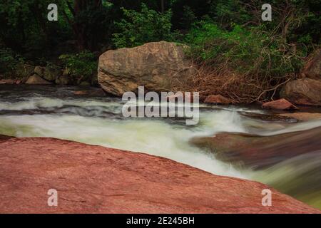 Écoulement fluide et soyeux de l'eau dans les chutes Thirumoorthy (aussi connu sous le nom de chutes Panchalingam en langue tamoule), Udumalpet, Tamil Nadu, Inde. Foc sélectif Banque D'Images