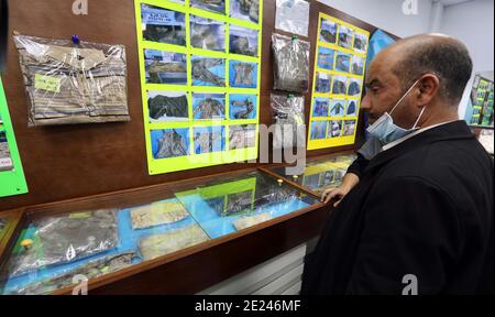 (210112) -- TRIPOLI, le 12 janvier 2021 (Xinhua) -- UN homme regarde des photos et des objets appartenant à des corps non identifiés dans une exposition qui s'est tenue à Tripoli, en Libye, le 11 janvier 2021. Les autorités libyennes ont récupéré quatre corps non identifiés dans une fosse commune récemment découverte dans la ville de Tarhuna, a déclaré à Xinhua Abdulaziz Ja'ven, porte-parole de l'Autorité générale pour la recherche et l'identification. Tarhuna, située à environ 90 km au sud de la capitale Tripoli, était autrefois le principal centre d'opération militaire de l'armée, basée à l'est, pendant la guerre contre le gouvernement soutenu par l'ONU à Tripoli et autour. Depuis la mendier Banque D'Images