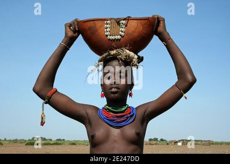 Jeune Tribu Dassanech tenant Gourd traditionnel, Omorate, Omo Valley, Ethiopie Banque D'Images