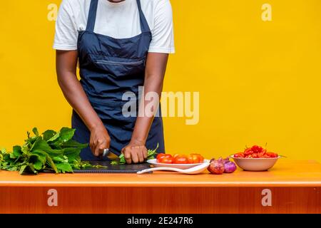 chef africain féminin coupant des légumes sur une table, mains seulement Banque D'Images