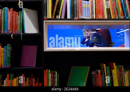 Grand-père lisant le livre aux petits-fils dans la bibliothèque Banque D'Images