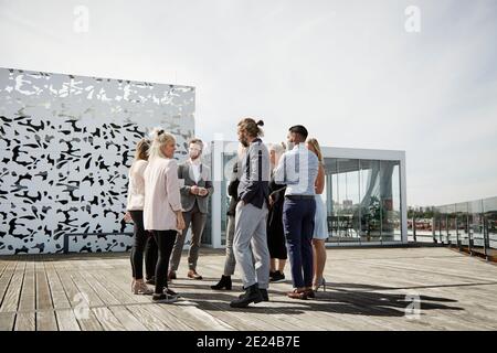 Personnes debout devant un bâtiment moderne Banque D'Images