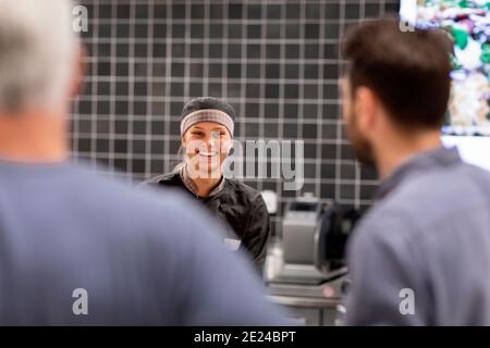 Femme souriante assistant boutique Banque D'Images