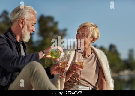 Couple souriant ayant du vin Banque D'Images