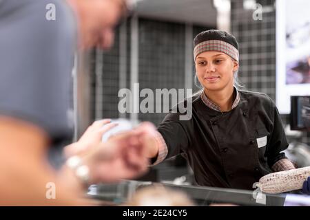 Femme souriante assistant boutique Banque D'Images