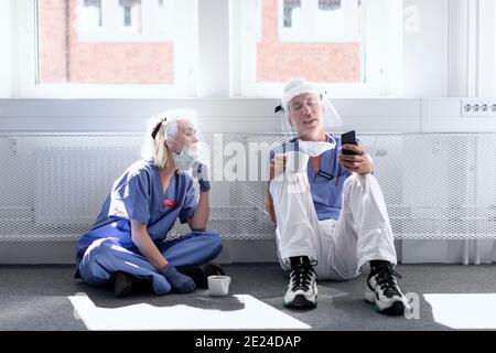 Les médecins portant un équipement de protection individuelle lors de la pause-café Banque D'Images