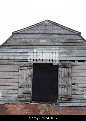 Ancienne grange en briques et bois avec portes de chargement au 1er étage à Westbury, Wiltshire, Angleterre, Royaume-Uni. Banque D'Images