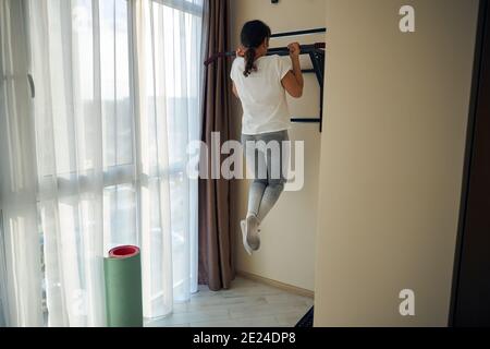 Femme avec une queue de cheval effectuant un exercice d'entraînement de force Banque D'Images