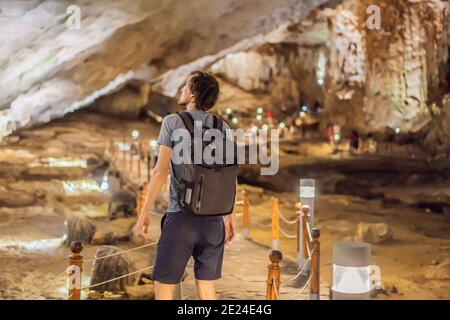 Homme touristique à Hang Sung Sot Grotto Cave of surprise, baie d'Halong, Vietnam Banque D'Images