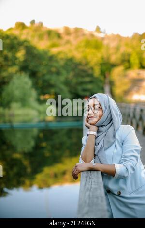 Femme souriante portant le hijab regardant loin Banque D'Images