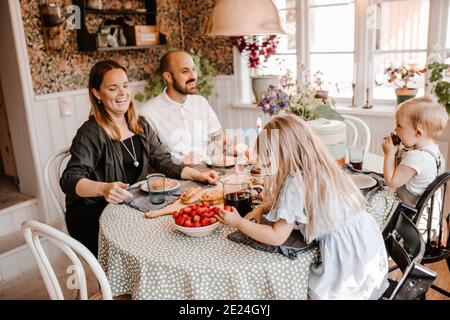 Famille souriante prenant un repas ensemble Banque D'Images