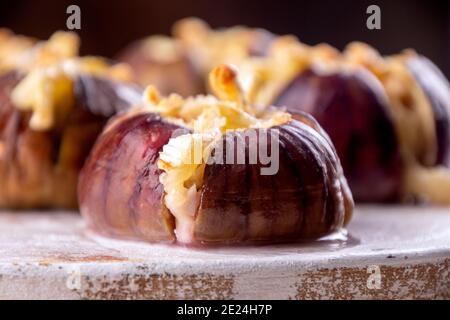 Figues mûres cuites au lait de vache brie et au camambert et parsemée de chapelure ornée de feuilles de menthe. Concept de saine alimentation. Gros plan Banque D'Images