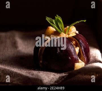 Figues mûres cuites au fromage de lait de vache brie et au camambert et parsemée de chapelure, décorées de feuilles de menthe, concept de saine alimentation. Dark mi Banque D'Images