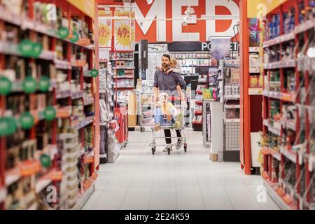 Père avec des filles faisant du shopping dans un supermarché Banque D'Images