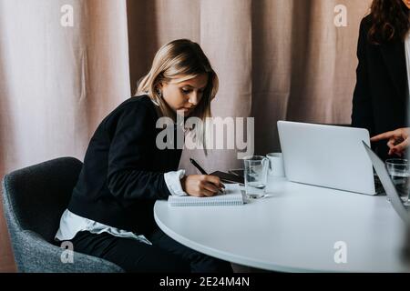 Femme au bureau prenant des notes Banque D'Images