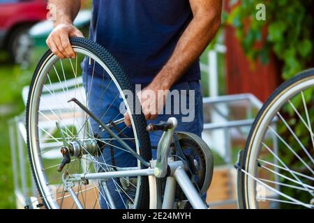 Gros plan d'un homme qui répare un vélo Banque D'Images
