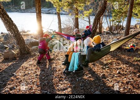 Enfants sur des hamacs au bord du lac Banque D'Images