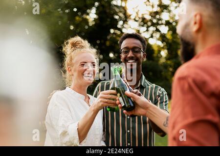 Des amis heureux de boire de la bière dans le jardin Banque D'Images