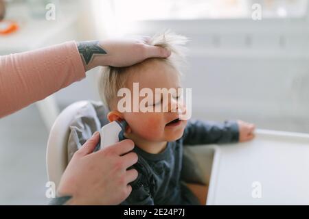 La mère vérifie la température de l'enfant Banque D'Images