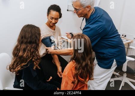 Médecin vérifiant la tension artérielle des femmes Banque D'Images