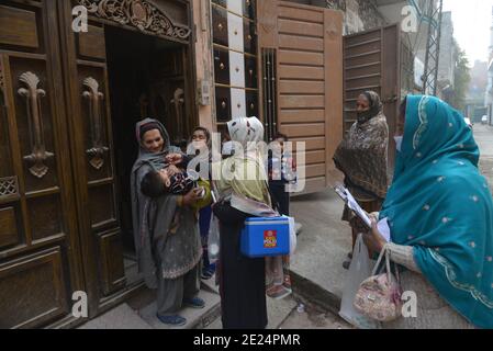 Un travailleur de la santé pakistanais administre un vaccin contre la polio à un enfant Au cours d'une campagne de vaccination de porte à porte contre la polio à Lahore Banque D'Images