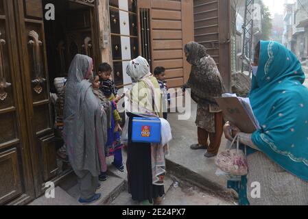 Un travailleur de la santé pakistanais administre un vaccin contre la polio à un enfant Au cours d'une campagne de vaccination de porte à porte contre la polio à Lahore Banque D'Images