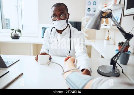 Therapeutist en appuyant sur le bouton d'un moniteur de tension artérielle électronique Banque D'Images