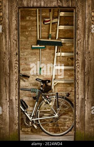 Image de style rétro d'un hangar avec un vélo et outils de jardin à l'intérieur Banque D'Images