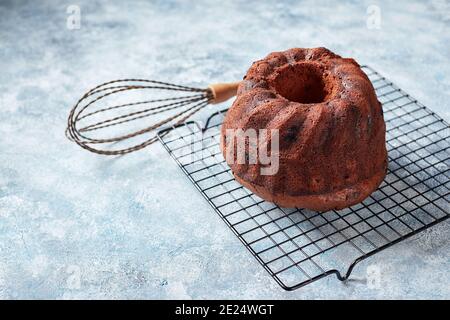 Gâteau au chocolat sur une grille métallique, sucre en poudre et canneberges dans des bols, préparés pour la décoration Banque D'Images