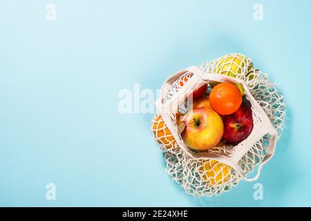 Sac en mesh avec fruits sur fond couleur. Banque D'Images