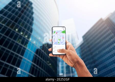 Application de navigation Smartphone avec application GPS à l'écran avec main noire Banque D'Images