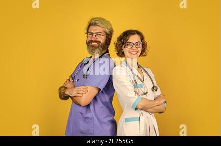 Équipe réussie de médecins. Personnes en uniforme fond jaune. Personnel médical. Faites confiance à nos professionnels de santé. Travail d'équipe et concept de personnes. Médecin et infirmière. Banque D'Images