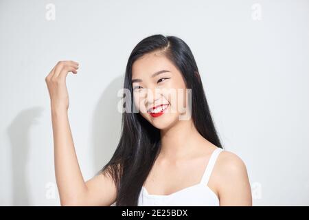 Studio de photo de jeune femme charmante aux cheveux foncés avec un maquillage festif, à l'écart Banque D'Images