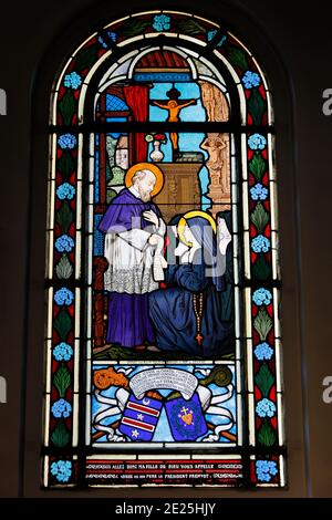 Église Saint Honoré d'Eylau, Paris, France. Vitrail. Ste Jeanne de Chantal, fondatrice de l'ordre de la Visitation de Marie, reçoit le constit Banque D'Images