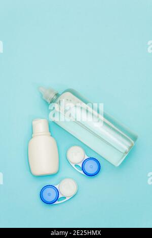 Kit de voyage pour lentilles de contact. Assainisseur, solution, récipients. Arrière-plan bleu clair Banque D'Images