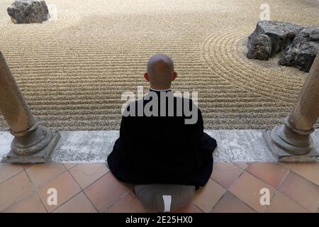 Moine bouddhiste Zen pratiquant le zazen (méditation) dans le jardin zen de l'abbaye trappiste d'Orval, Belgique. Banque D'Images