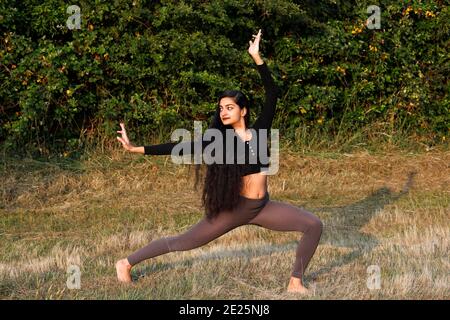 Jeune femme faisant du yoga dans un jardin à Eure, France Banque D'Images