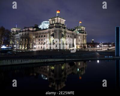 Berlin, Allemagne. 10 janvier 2021. Les lumières de la rue sur les rives du Reichstag et du Reichstag se reflètent dans la soirée par la surface de l'eau de la Spree. Credit: Soeren Stache/dpa-Zentralbild/ZB/dpa/Alay Live News Banque D'Images