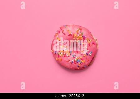 un seul donut rose sur un fond rose assorti avec glaçage rose et saupoudrer avec espace de copie et espace pour texte avec composition centrale Banque D'Images