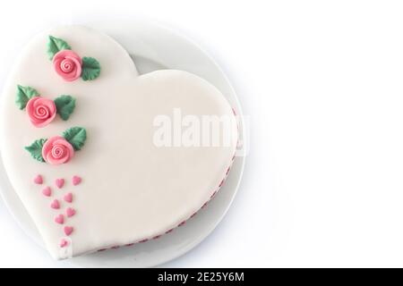 Gâteau de coeur pour la Saint-Valentin, la fête des mères ou l'anniversaire, décoré de roses et de coeurs de sucre rose Banque D'Images