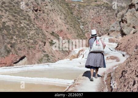 Salines à Salinas.Un ouvrier porte du sel le long des terrasses. Banque D'Images