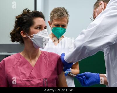 12 janvier 2021, Saxe-Anhalt, Halle (Saale): Tonja Weber (l), médecin senior, est vacciné contre le coronavirus à l'hôpital universitaire de Halle/Saale (UKH) par le professeur Thomas moesta, directeur médical de l'UKH, tandis que l'infirmière Dagmar Wieland prépare le vaccin Covid 19. Le nouveau vaccin de Moderna est utilisé pour la première fois. Les employés de l'UKH sont vaccinés. Photo: Hendrik Schmidt/dpa-Zentralbild/dpa Banque D'Images