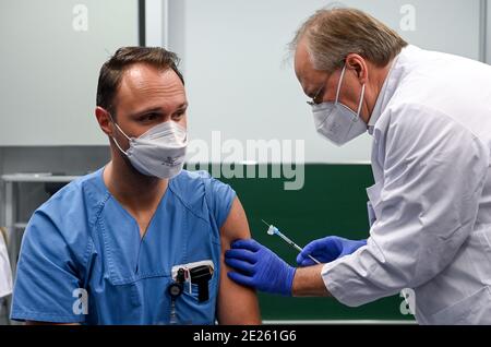 12 janvier 2021, Saxe-Anhalt, Halle (Saale): Michael Meixner (l) du département de soins infirmiers est vacciné contre le coronavirus à l'hôpital universitaire de Halle/Saale (UKH) par le professeur Thomas moesta, directeur médical de l'UKH. Le nouveau vaccin de Moderna est utilisé pour la première fois. Les employés de l'UKH seront vaccinés. Photo: Hendrik Schmidt/dpa-Zentralbild/dpa Banque D'Images